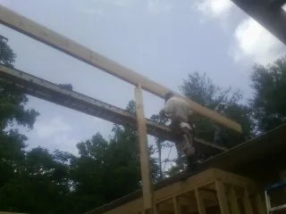 Carpenter setting a ridge beam over a new addition frame — Ice Dam Removal by Roofing Brothers in Lisle